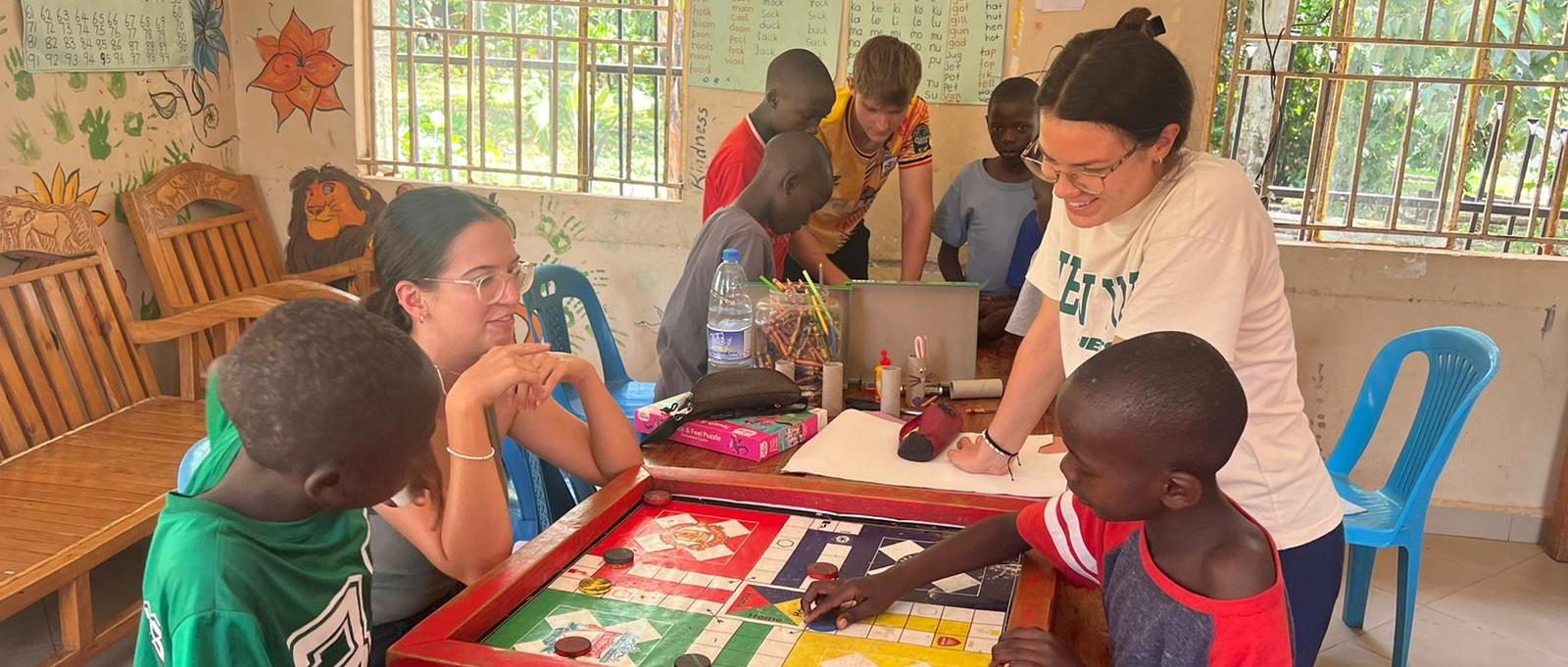 Freiwillige mit Kindern am Tisch